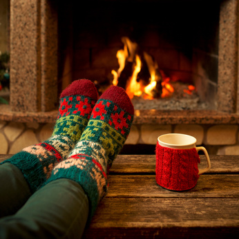 Füße in Wollsocken vor dem Kamin